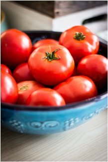 Ripe red tomatoes in a blue bowl